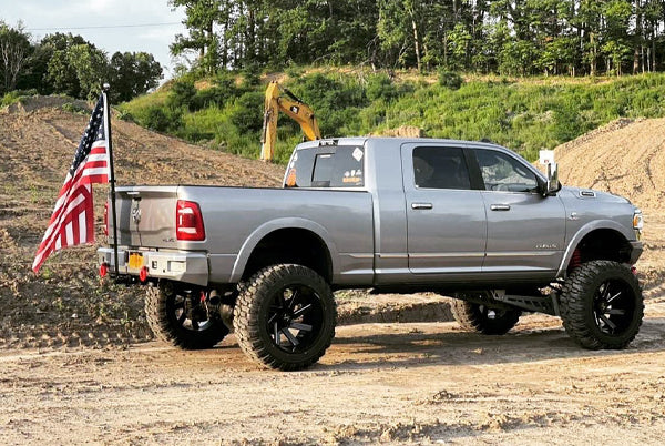 Lifted pickup flying an American flag on a FanPole hitch flag pole